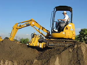 Excavation work in progress at a construction site using a compact excavator John Deere 27C ZTS